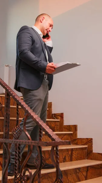 Office executive speaking on smartphone standing on stairs — Stock Photo, Image