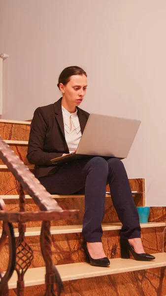 Empregado usando laptop excesso de trabalho sentado nas escadas — Fotografia de Stock
