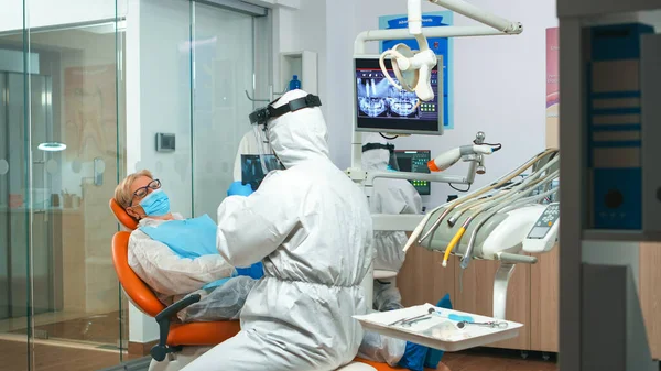 Стоматолог в защитном костюме просит рентген зубов — стоковое фото