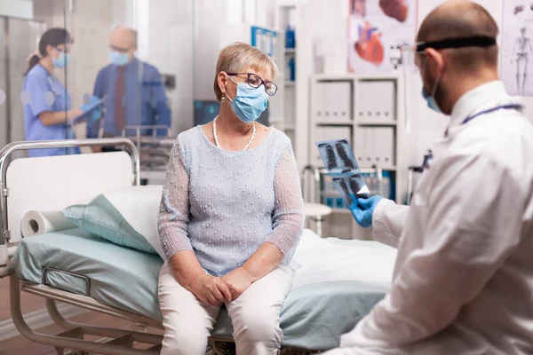 Dokter legt röntgenfoto 's uit aan zieke oudere vrouw — Stockfoto