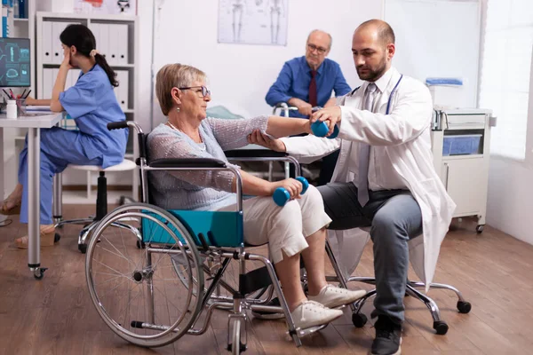 Medische therapeut helpt gehandicapte oudere vrouw — Stockfoto