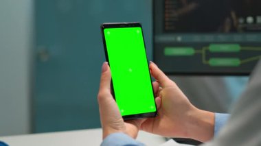 Kimyager yeşil ekranlı akıllı telefondan hasta sonuçlarını kontrol ediyor.