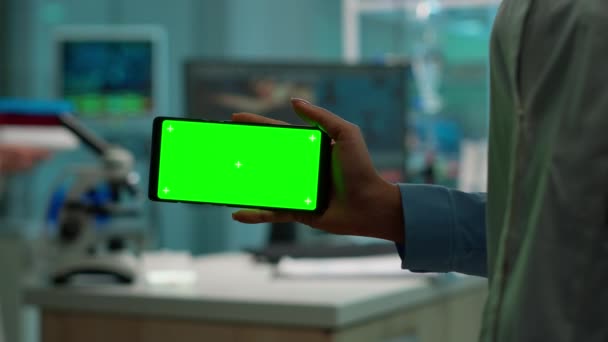 Микробиолог держит смартфон с дисплеем с зеленой хромой — стоковое видео
