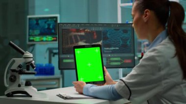 Yeşil renkli ekranlı tablet tutan bilim adamı