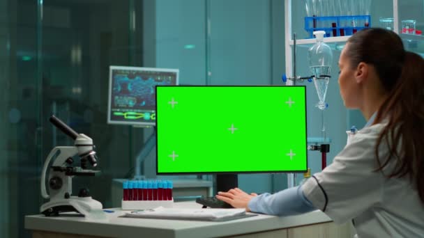 Sobre la toma de hombro del químico que trabaja con la pantalla verde — Vídeos de Stock