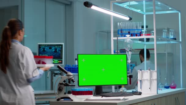 Químicos trabalhando no fundo do laboratório usando pc com tela verde — Vídeo de Stock