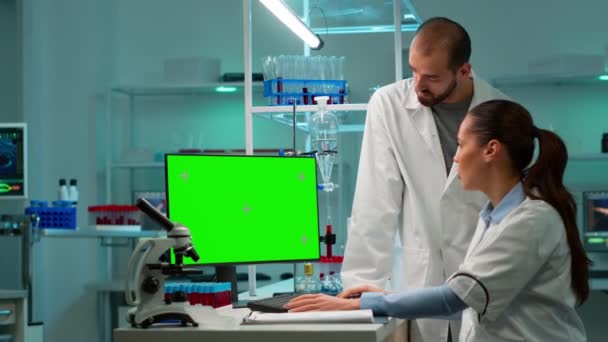 Wissenschaftler diskutieren vor Computer mit grünem Chroma-Tastenschirm — Stockvideo