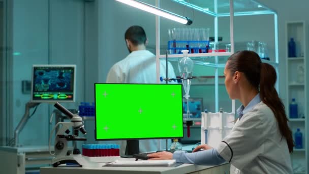 Científico sentado en el escritorio trabajando en el ordenador personal con pantalla simulada — Vídeos de Stock