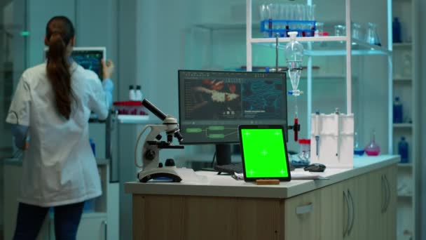 Tableta con pantalla de croma verde colocada en el escritorio en el laboratorio — Vídeos de Stock