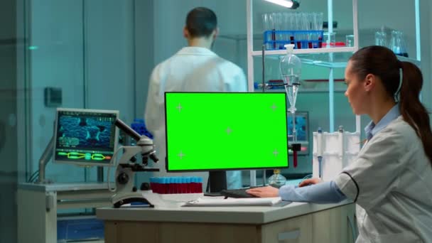 Bioquímico sentado en el lugar de trabajo utilizando la pantalla de maqueta verde pc — Vídeos de Stock