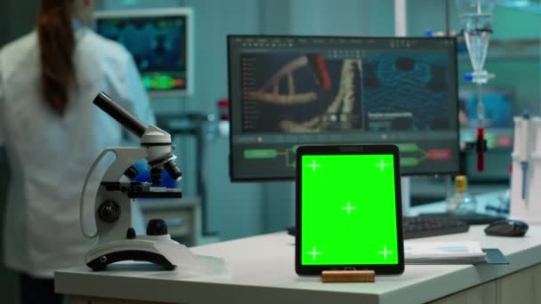 Tableta con pantalla verde simulada colocada delante de la cámara en el laboratorio — Vídeos de Stock