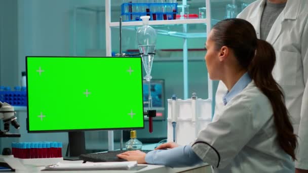 Mann spricht mit Labortechniker und arbeitet mit grünem PC-Attrappen — Stockvideo