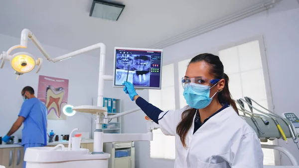 Médico dentista y paciente mirando rayos X digitales — Foto de Stock