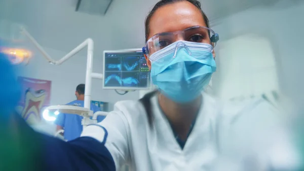 Dentista inclinado sobre paciente poniendo máscara de oxigeno, paciente pov — Foto de Stock