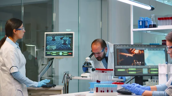 Man research scientist looking at samples under microscope — Stock Photo, Image