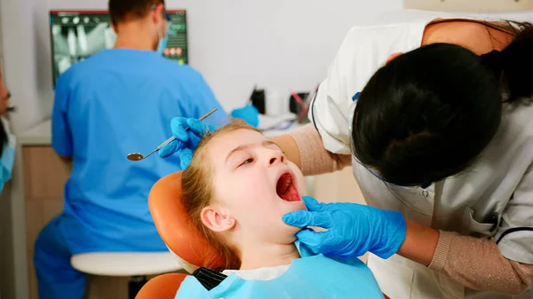 Close up de menina paciente deitado em cadeira estomatológica com a boca aberta — Fotografia de Stock