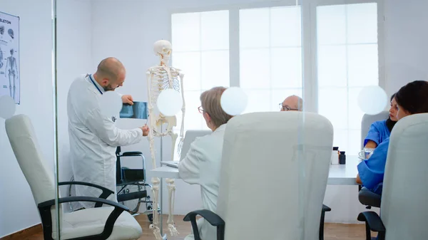 Artsen leren collega 's lichaam bot functie met behulp van x-ray en menselijk skelet — Stockfoto