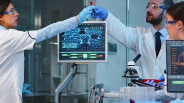 Mikroskop altında biyolojik araştırma yapan bilim adamlarından oluşan bir ekip.