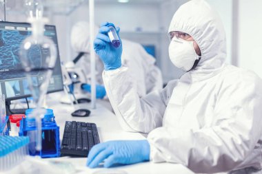 Güvenlik önlemi olarak laboratuvar teknisyeni koruyucu kıyafet giymişti.