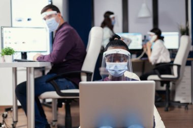 Siyah yönetici dizüstü bilgisayarda not alıyor