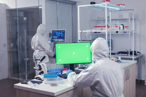 Вчений проводить експеримент з використанням комп'ютера з зеленим екраном — стокове фото