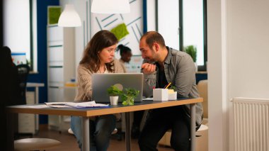 Dizüstü bilgisayar kullanan genç iş adamları, yeni bir başlangıç fikri gösteriyorlar