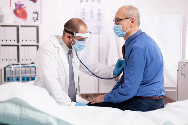 Arts luisteren oudere patiënt hart met behulp van stethoscoop — Stockfoto