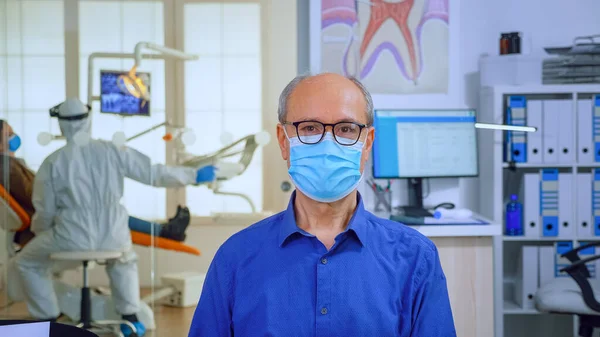 Porträt eines älteren Mannes mit Maske in Zahnarztpraxis vor laufender Kamera — Stockfoto