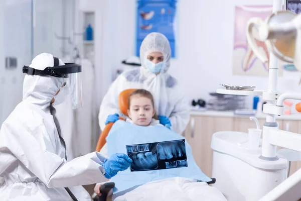 Стоматолог в чехле для осмотра зубов, одетый в костюм ppe — стоковое фото