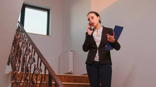 Empresária falando ao telefone em pé nas escadas — Fotografia de Stock