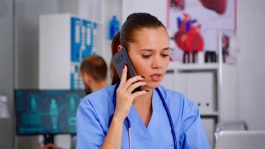 Tıp asistanı akıllı telefonda konuşuyor. Doktordan tavsiye istiyor.