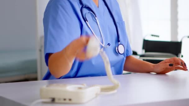 Медицинская секретарша отвечает на звонки пациента — стоковое видео