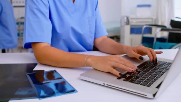 Zbliżenie pielęgniarki medycznej piszącej wyniki radiografii pacjenta — Wideo stockowe
