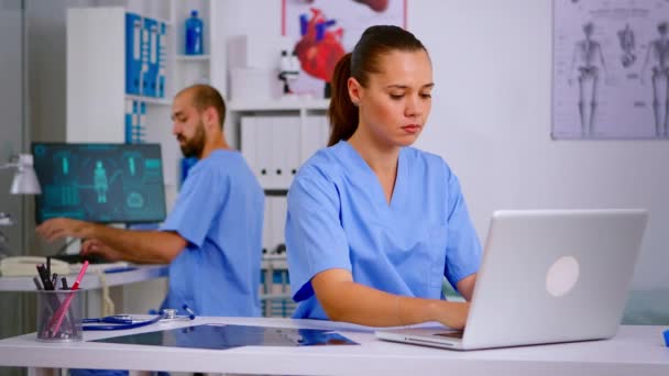 ノートパソコンに患者の健康報告書を入力する医療従事者 — ストック動画