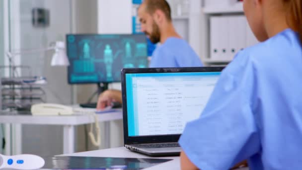 Profesyonel doktor asistanı laptoptaki tıbbi kayıtları kontrol ediyor. — Stok video