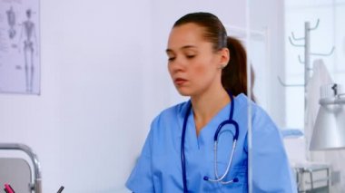 Doktor asistanı hastaneden telefonla hastayla konuşuyor.