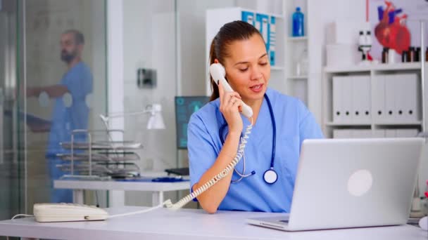 Enfermeira médica atendendo chamada do paciente por telefone — Vídeo de Stock