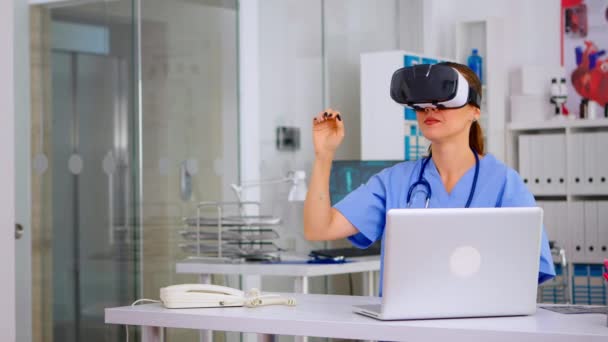 Asistentă medicală care se confruntă cu realitatea virtuală folosind ochelari de protecție vr în spital — Videoclip de stoc
