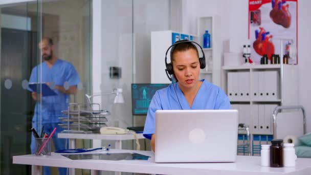 Assistant offrant des services médicaux à l'aide d'écouteurs répondant aux appels, — Video