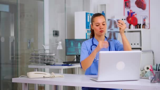 Krankenschwester hält Patientin Röntgenbild auf Laptop — Stockvideo