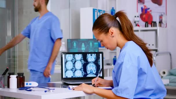 Assistant expert médecin en uniforme médical examinant la radiographie numérique — Video