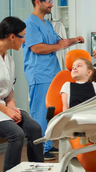 Hombre enfermera invitando a niño paciente en consulta sala dental —  Fotos de Stock