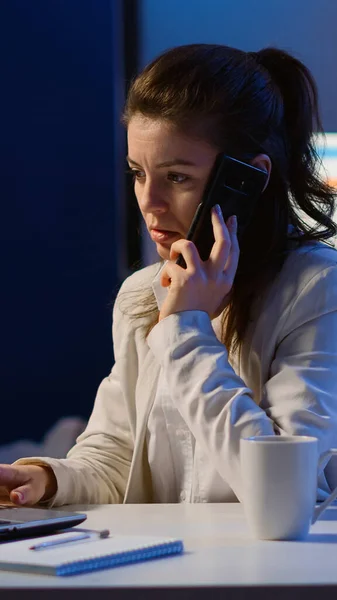 Donna dipendente che parla al telefono mentre lavora al computer portatile — Foto Stock