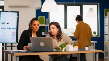 Modern ofiste dizüstü bilgisayar kullanarak çalışan yönetici ve kreatif direktör