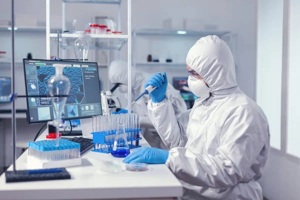 Científico sanitario tomando muestras del tubo de ensayo usando pipeta automática —  Fotos de Stock