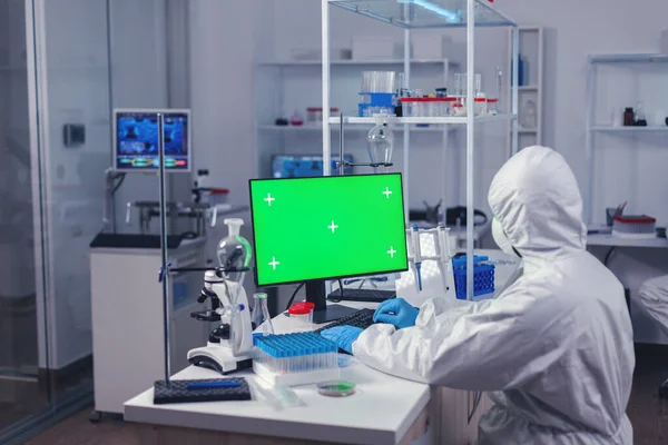 Medical engineer conducting research on computer with green screen