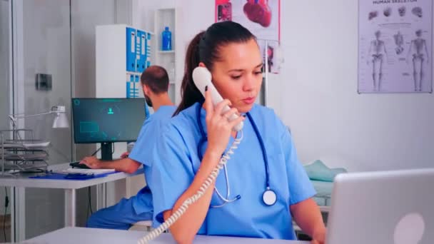 Medical team working in hospital, nurse talking on phone — Stock Video