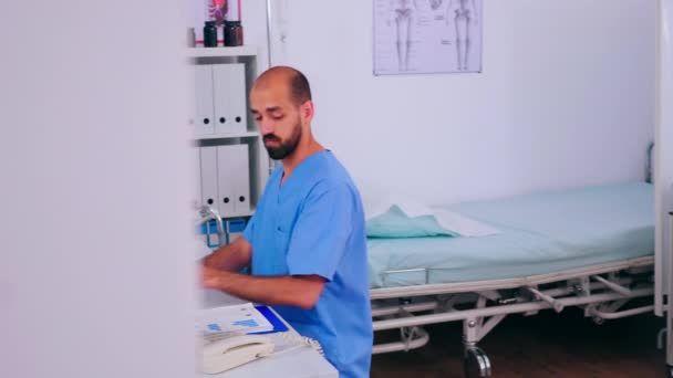 Врач, отвечающий на телефонные звонки, работает в больнице — стоковое видео