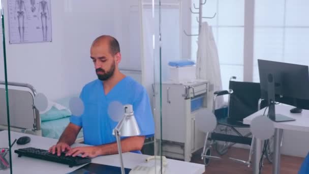 Assistant talking at phone, checking appointment while woman working at computer — Stock Video