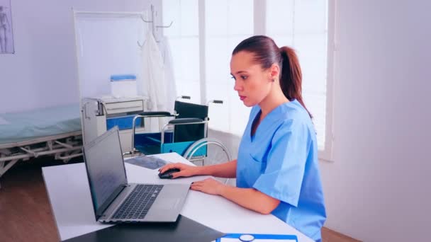 Krankenschwester analysiert Liste der Patienten auf Laptop — Stockvideo